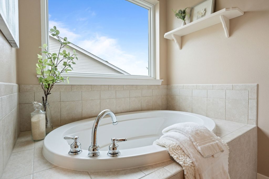Real Estate Photography Services: A bathroom with a tub and a window, captured in impressive detail.