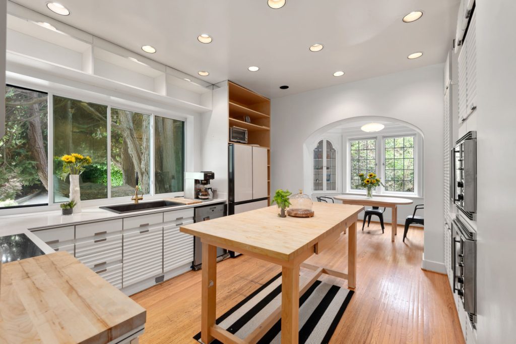 Real Estate Photography Services: Capturing a kitchen with white cabinets and a wooden island.